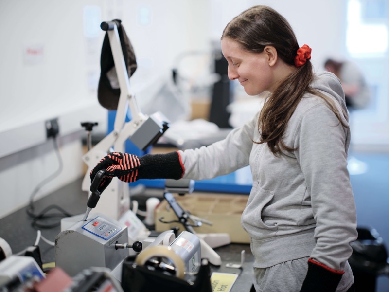 Woman working the shirt printing press